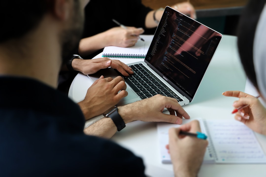 Hands over a laptop and notebook in a working session