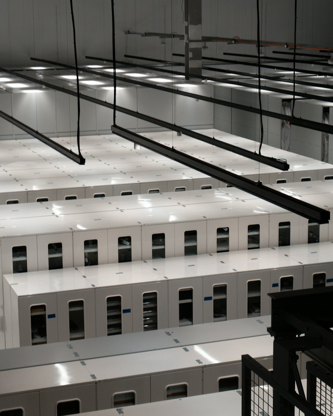 Rows of white server cabinets in a modern data centre hall