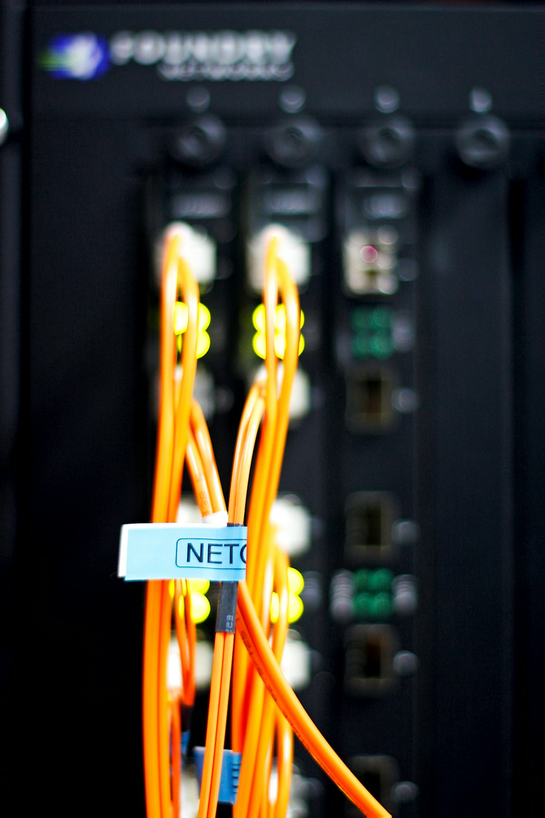 Orange fibre patch cords plugged into a network switch