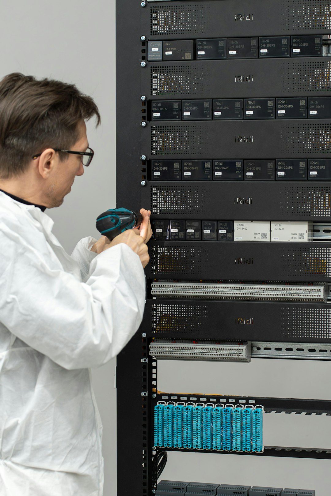 Engineer in a lab coat installing a rack server