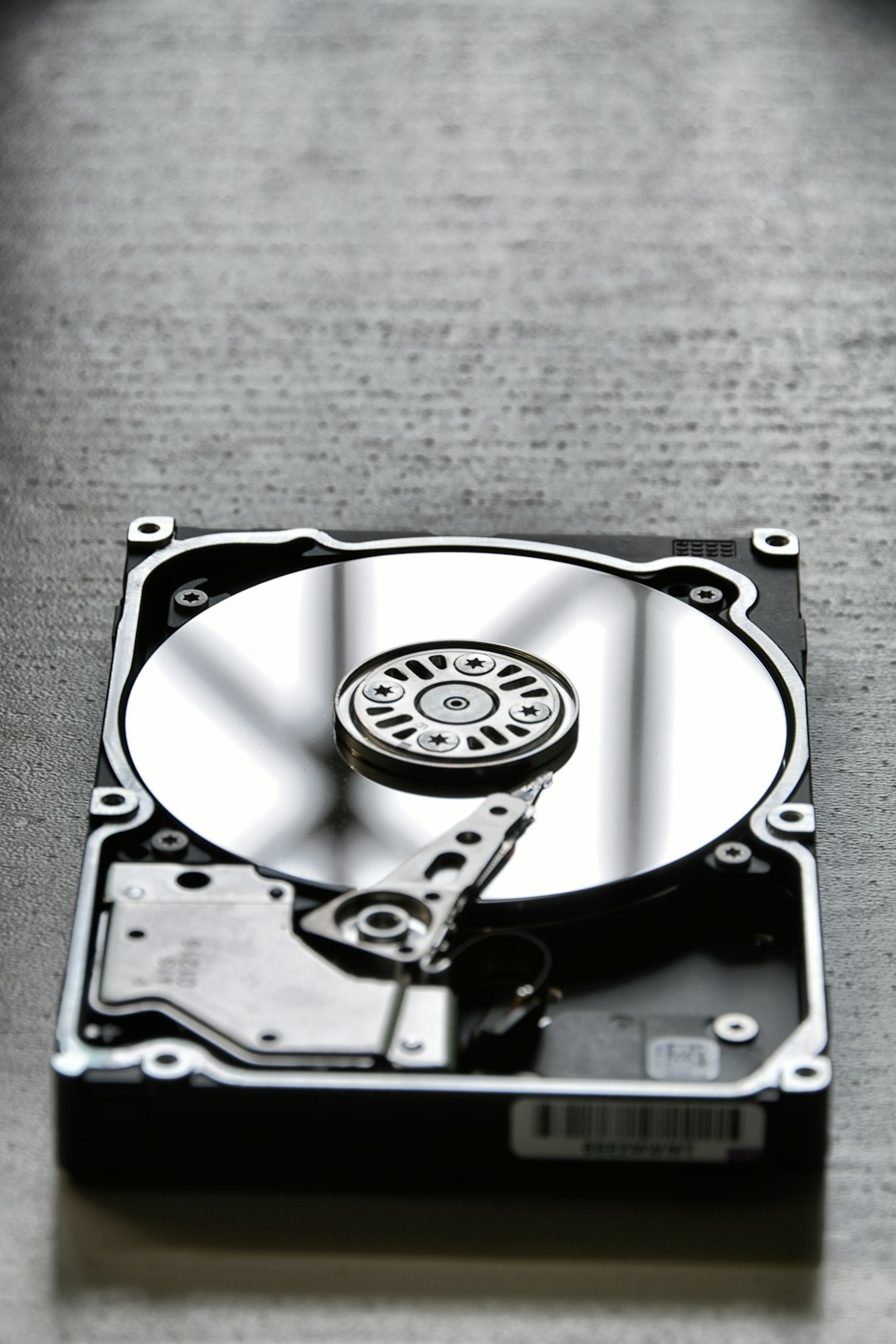 Open hard disk drive showing the platter and read head